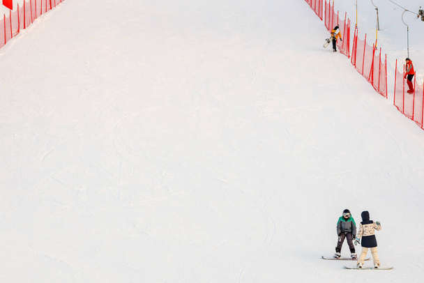 un par de snowboarders al final de la pista cercada. dos amigos cabalgan en invierno - Foto, Imagen