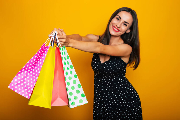 Beautiful happy young stylish brunette woman in a dress is posing with many colorful shopping bags and having fun - Fotoğraf, Görsel
