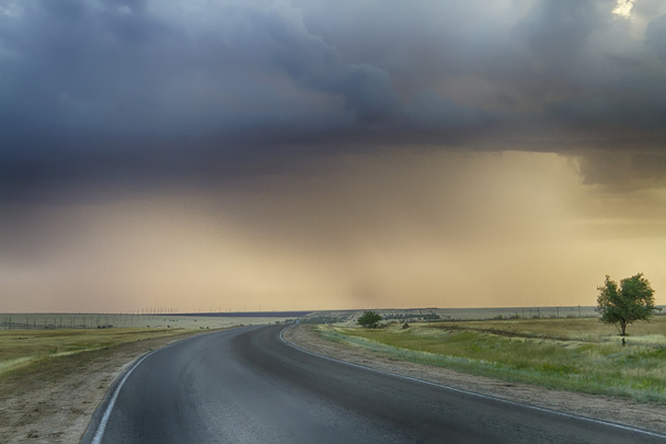 Асфальтовая дорога сошла под бурным небом
 - Фото, изображение