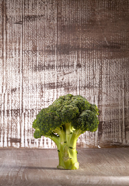 Single crown broccoli on the kitchen table in the grunge background - Φωτογραφία, εικόνα