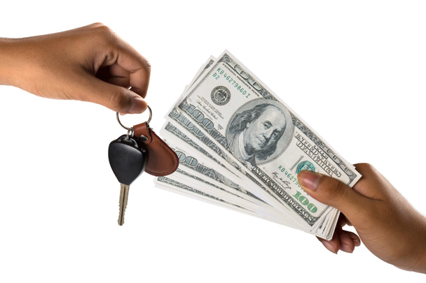 hand met geld en auto sleutels - Foto, afbeelding