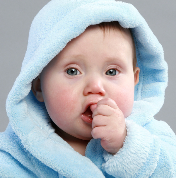 αξιολάτρευτο μωρό αγόρι σε μπλε μπουρνούζι σε γκρι φόντο - Φωτογραφία, εικόνα