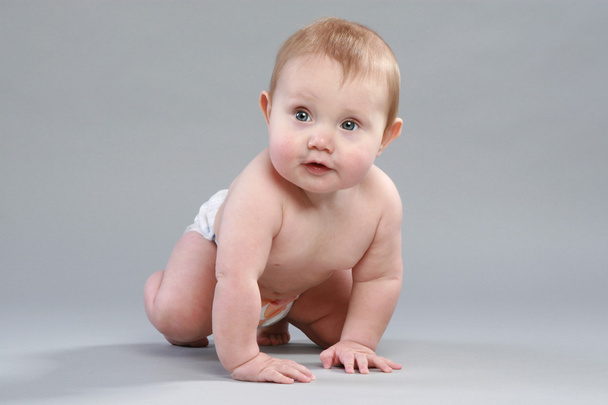 Little boy in pampers crawling on grey background - Fotografie, Obrázek
