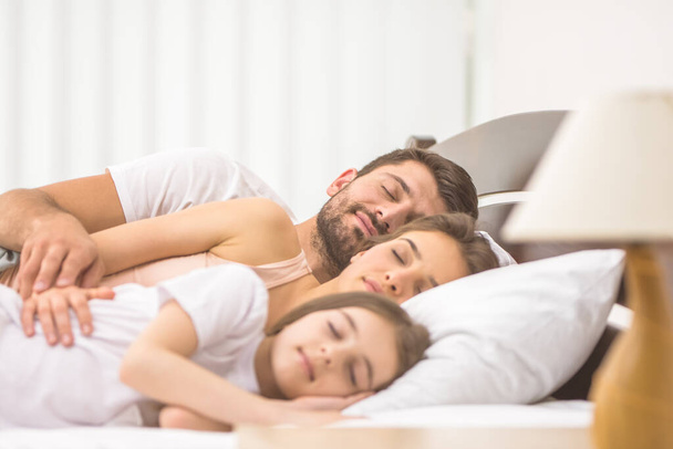 Die glückliche Familie schläft auf dem bequemen Bett - Foto, Bild