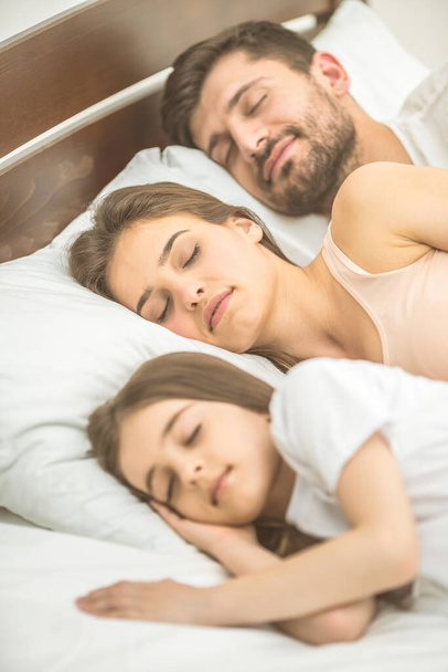 The family sleeping on the comfortable bed - Foto, afbeelding