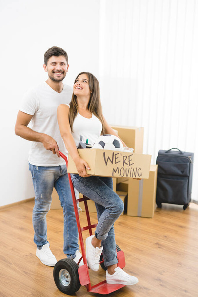 El hombre y la mujer felices moviéndose al nuevo piso - Foto, Imagen