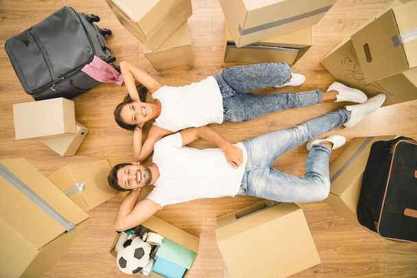 The happy man and woman lay on the floor near boxes. view from above - Photo, Image