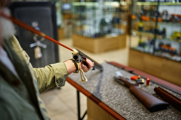 Чоловічий мисливець з рушницею Рамрода в магазині зброї
 - Фото, зображення