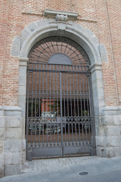 Halbkreisförmiger Eingang mit Metallgitter an einer Ziegelfassade - Foto, Bild