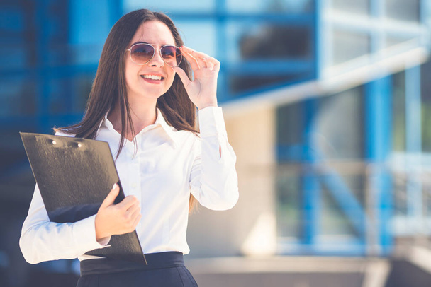 Щаслива бізнес-леді в сонцезахисних окулярах стоїть з планшетом
 - Фото, зображення