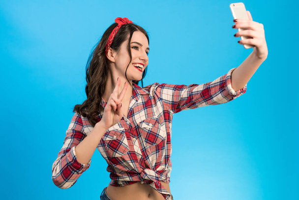 La donna carina fa un selfie sullo sfondo blu - Foto, immagini