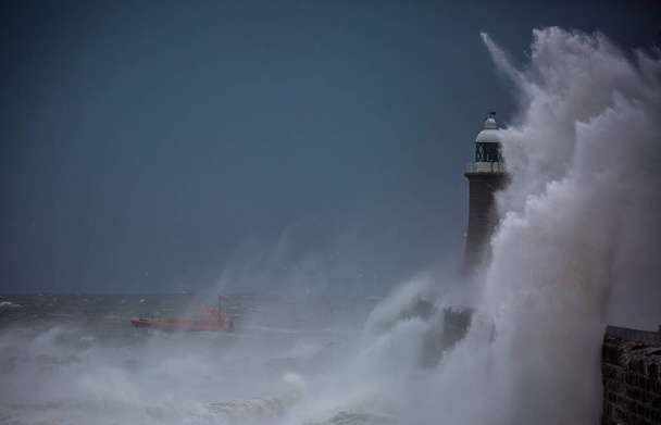 イギリス、タイネマスのタインの口を守る灯台と北の桟橋に打ち寄せる巨大な波 - 写真・画像