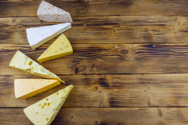 Conjunto de varios tipos de queso sobre mesa de madera. Vista superior, espacio de copia - Foto, imagen