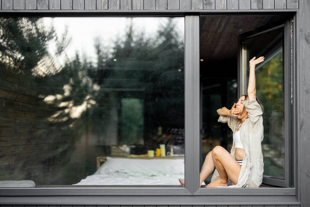 Жінка насолоджується природою в заміському будинку
 - Фото, зображення