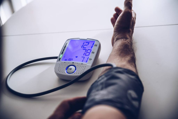 Miesten terveystarkastukset verenpaine ja syke digitaalisella painemittarilla. - Valokuva, kuva