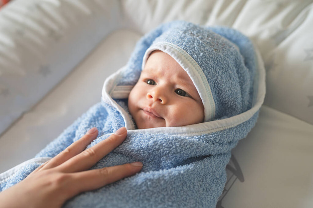 自宅で入浴後、青いタオルに包まれた小さな白人の赤ん坊 - 写真・画像