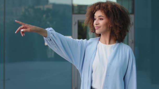 Outdoors portrait seductive flirting female ethnic curly lady african american woman afro girl looking to side points finger choose calling to come up doing invitation gesture welcome inviting call - Footage, Video