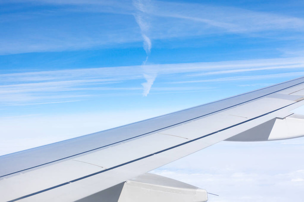 Aircraft wing in during the flight . Daytime flying with blue sky  - Foto, immagini