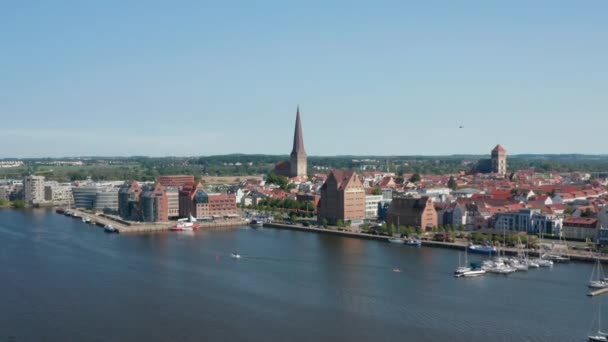 Vpřed letí nad hladinu. Letecký pohled na historickou část města s vysokou věží kostela sv. Petra - Záběry, video