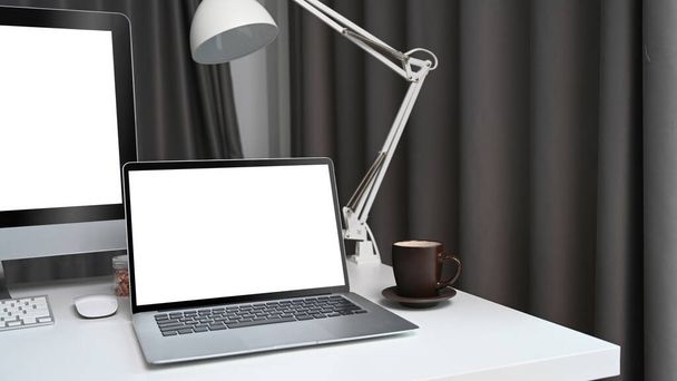現代の職場で白い机の上に空の画面とラップトップコンピュータをモックアップ. - 写真・画像