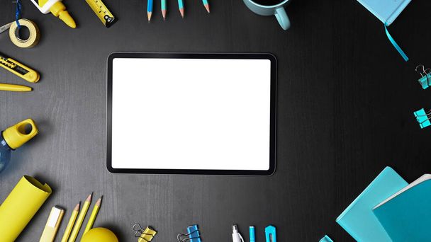 Mock up digital tablet with blank screen surrounded office supplies. - Zdjęcie, obraz