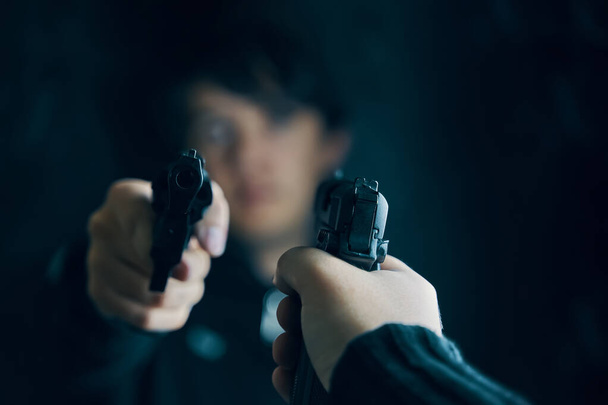 Mann mit Pistole auf Verbrecher mit Revolver gerichtet. - Foto, Bild