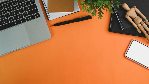 Mock up mobile phone, laptop, houseplant and notebook orange background. - Photo, Image