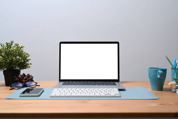 Mock up számítógép laptop, mobil pone, kávéscsésze és szobanövény fa íróasztalon. - Fotó, kép