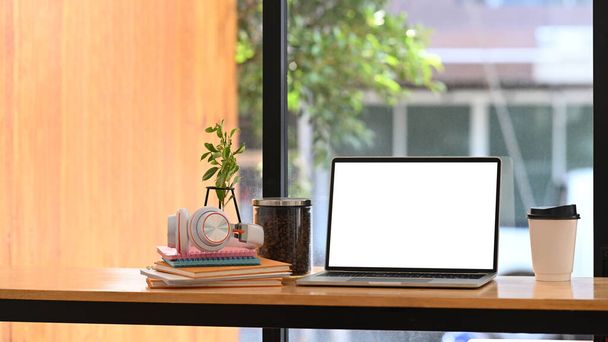 Laptop bilgisayarı, ev bitkisi, kahve fincanı kulaklığı ve rahat iş yerinde kitapları.. - Fotoğraf, Görsel