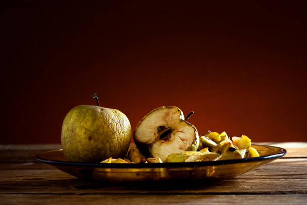 apples in a glass plate on wooden table - Foto, Imagen