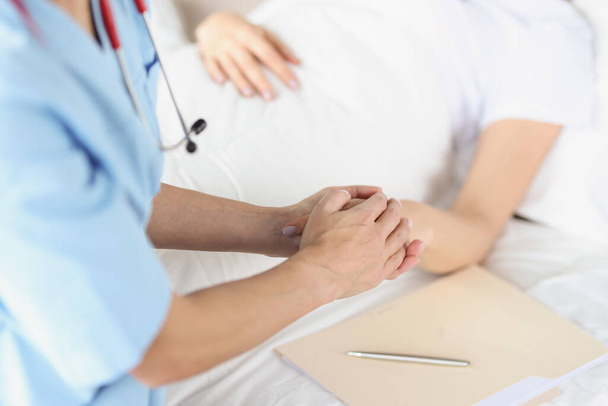 Žena lékař ruku drží za ruce ležícího pacienta v nemocnici - Fotografie, Obrázek
