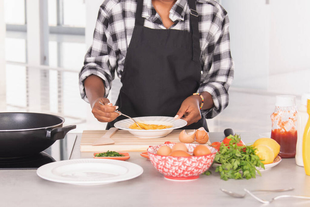 Mujer afroamericana calificada batiendo huevos en un plato. Concepto de cocina - Foto, Imagen