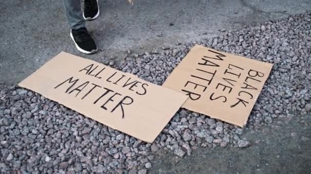 Бумажные баннеры с надписями BLM, ALL LIVESMATTER, STOP RACISM лежат на земле - Кадры, видео