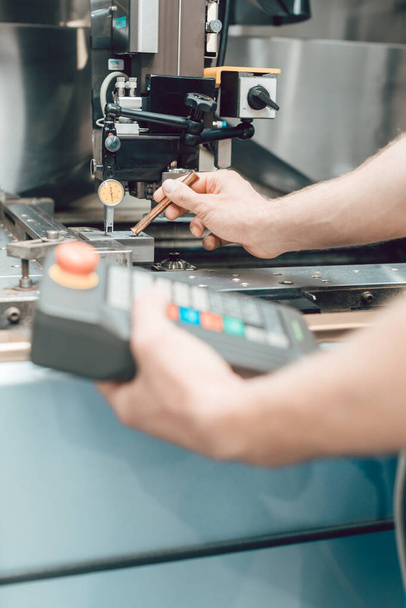 Εργαζόμενος στο εργοστάσιο βάζοντας εργαλείο σε ένα μηχάνημα διάτρησης - Φωτογραφία, εικόνα