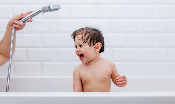 kleine peuter jongen neem een douche en bad - Foto, afbeelding