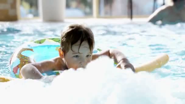 Little boy swimming in the pool with rubber ring - Footage, Video