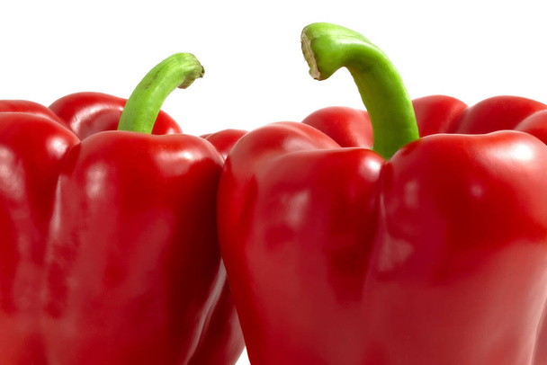 Δύο κόκκινες πιπεριές με πράσινα κοτσάνια κοντά - Φωτογραφία, εικόνα