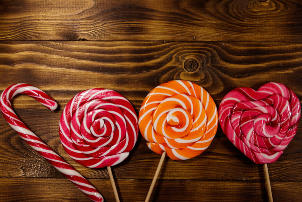 Sweet lollipops on rustic wooden background. Top view - 写真・画像