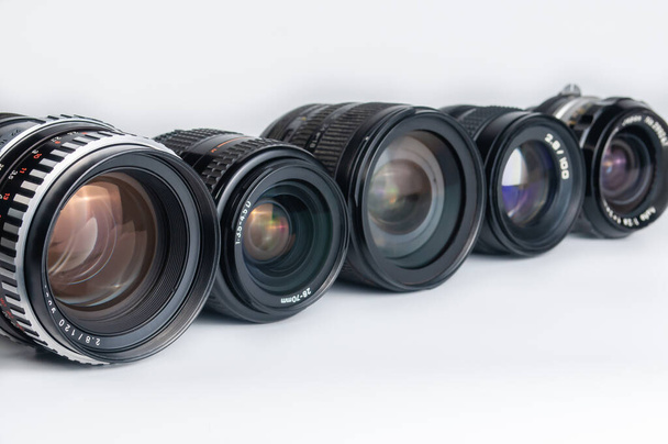 Beyaz arkaplanda modern ve eski DSLR kamera lensi seti - Fotoğraf, Görsel