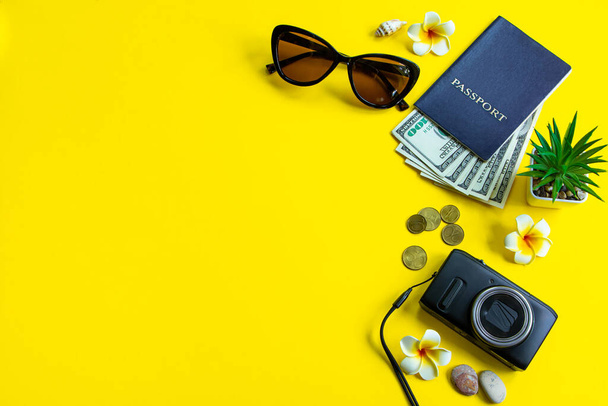 Sada stylových doplňků pro Vaši letní dovolenou. Léto cestování v čase. Cestovní pas, sluneční brýle, batoh a peníze na žlutém pozadí. - Fotografie, Obrázek