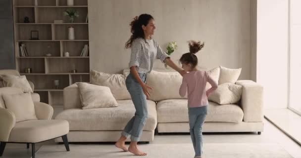 Boldog fiatal anya és kislánya táncol otthon. - Felvétel, videó