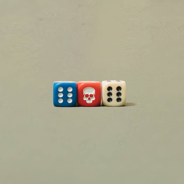 Dés arrangés rouge, bleu et blanc avec crâne et numéro six l'un à côté de l'autre. Conception minimale. - Photo, image