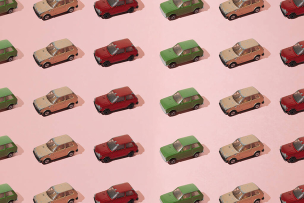 Τακτοποιήθηκε παλιό παιχνίδι σερβικό μικρό αυτοκίνητο. Μαρόν, πράσινο και μπεζ χρώμα. Ξεφλουδισμένη μπογιά. Ελάχιστος σχεδιασμός σε ροζ φόντο. Πρότυπο. - Φωτογραφία, εικόνα