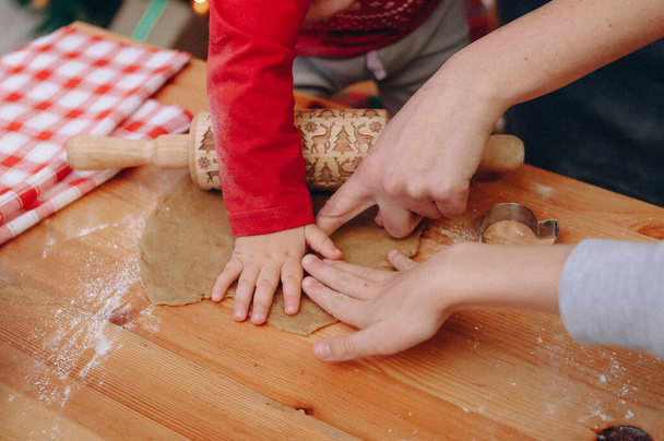 rolling dough rolling pin with christmas symbols cooking cookies kids hand - Foto, immagini