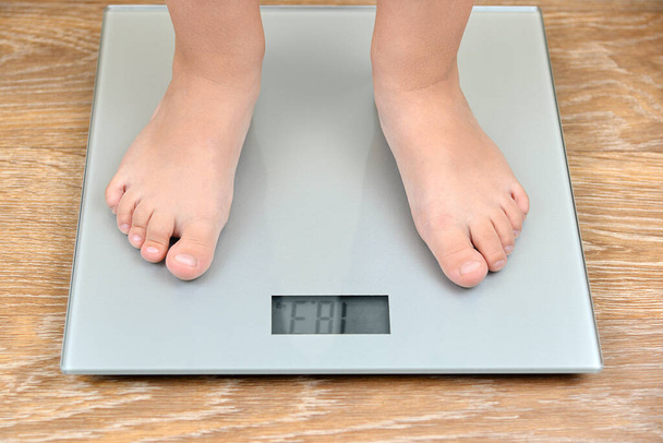 The feet of a three-year-old boy on the scales. - Photo, Image