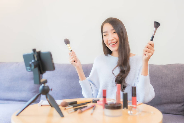 Ritratto bella giovane donna asiatica recensione cosmetico make up online a casa - Foto, immagini