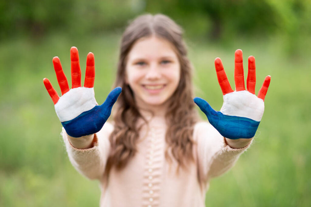 Croatia flag painted on child hands. Girl with open hands raised, focus on hands. Patriotic holiday. Independence Day, 25 June. Selective focus. Croatia Independence Day concept. Victory and Homeland - Photo, Image