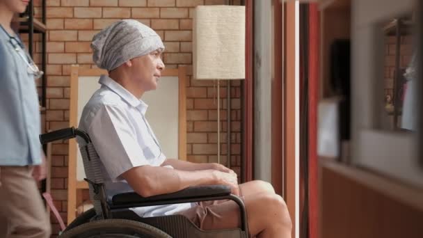 Kanker oudere patiënten in rolstoelen krijgen revalidatie behandeling in prive-huis, Aziatische vrouwelijke arts medische behandelingen door te praten om eenzaamheid te genezen en hen aan te moedigen met een glimlach. - Video