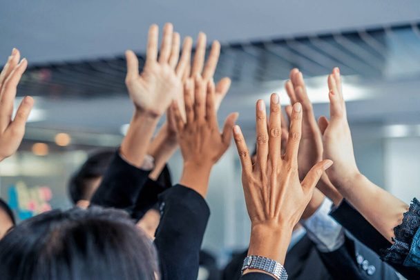 Muchos empresarios felices levantan las manos juntos. - Foto, Imagen