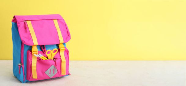 School backpack on table against color background with space for text - Photo, Image